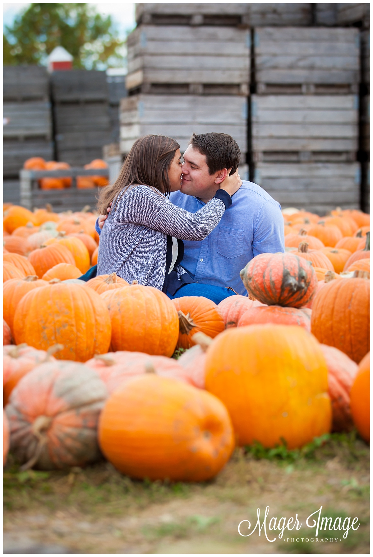 couple sitting in pumpkin patch