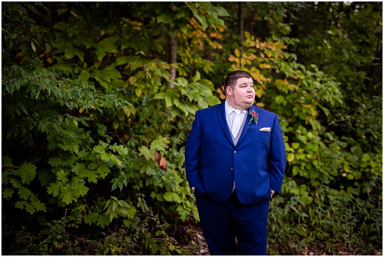 navy wedding tux with green ivy wall