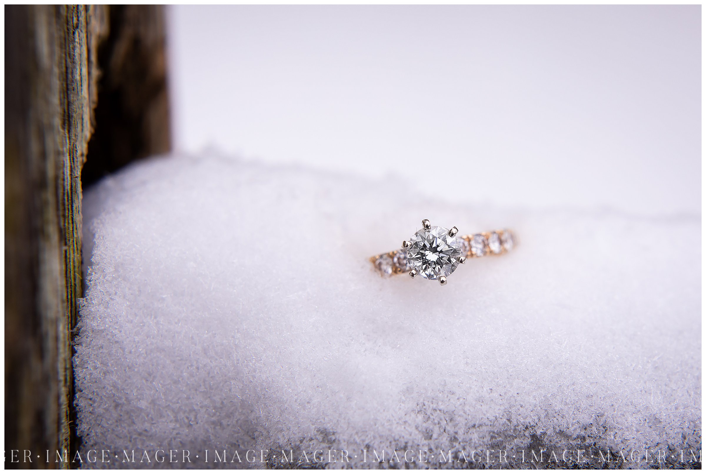 gold and silver engagement ring in snow
