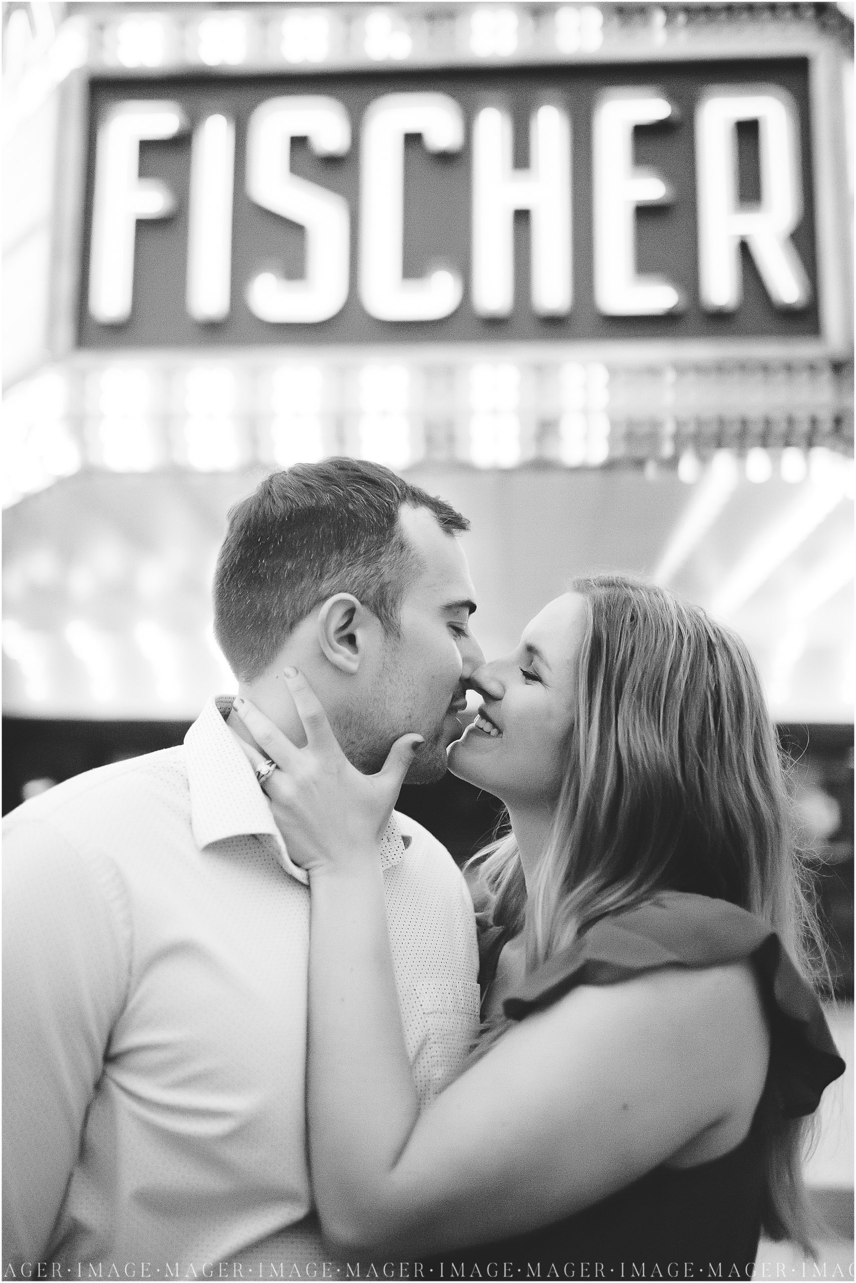 A close up, black and white image of a couple under the Fischer theater marquee sign in downtown Danville.

Photo taken by Mager Image Photography 