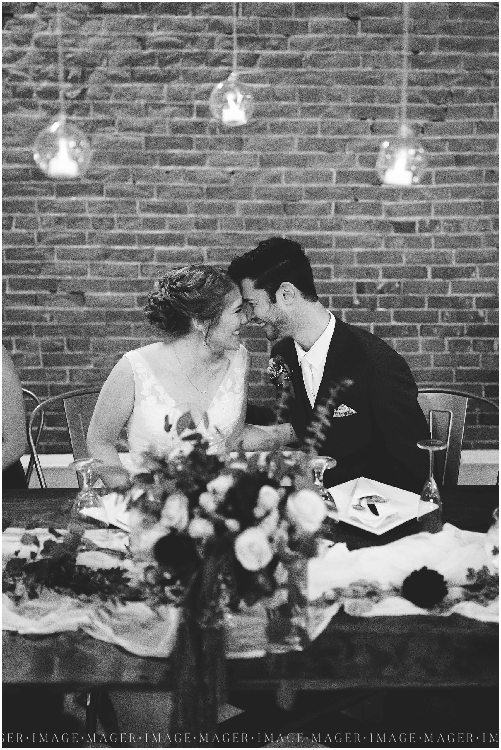 bride and groom romantic at head table, brick background, town and country events