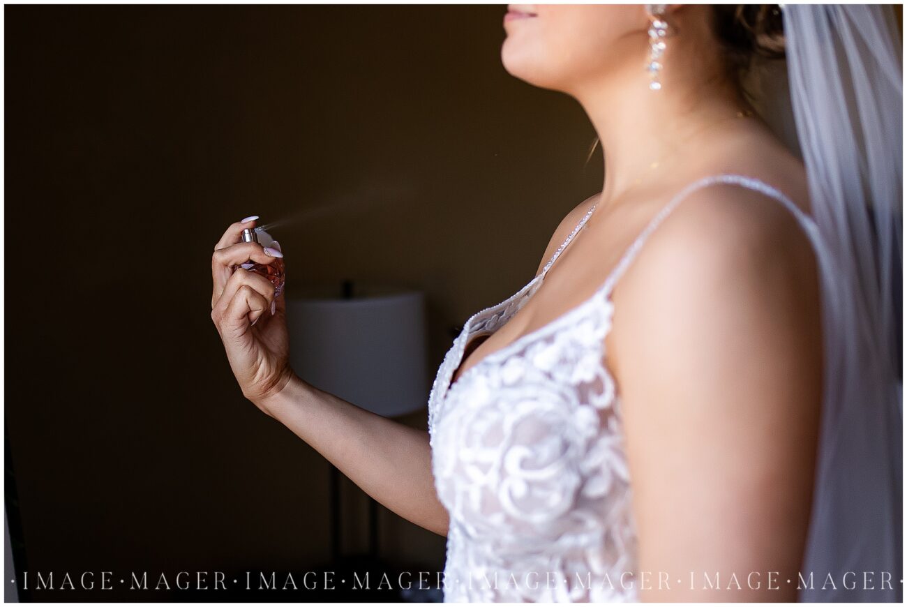 A small town wedding getting ready photo of the bride spraying perfume on.

L'erable, IL. Photo taken by Mager Image Photography.
