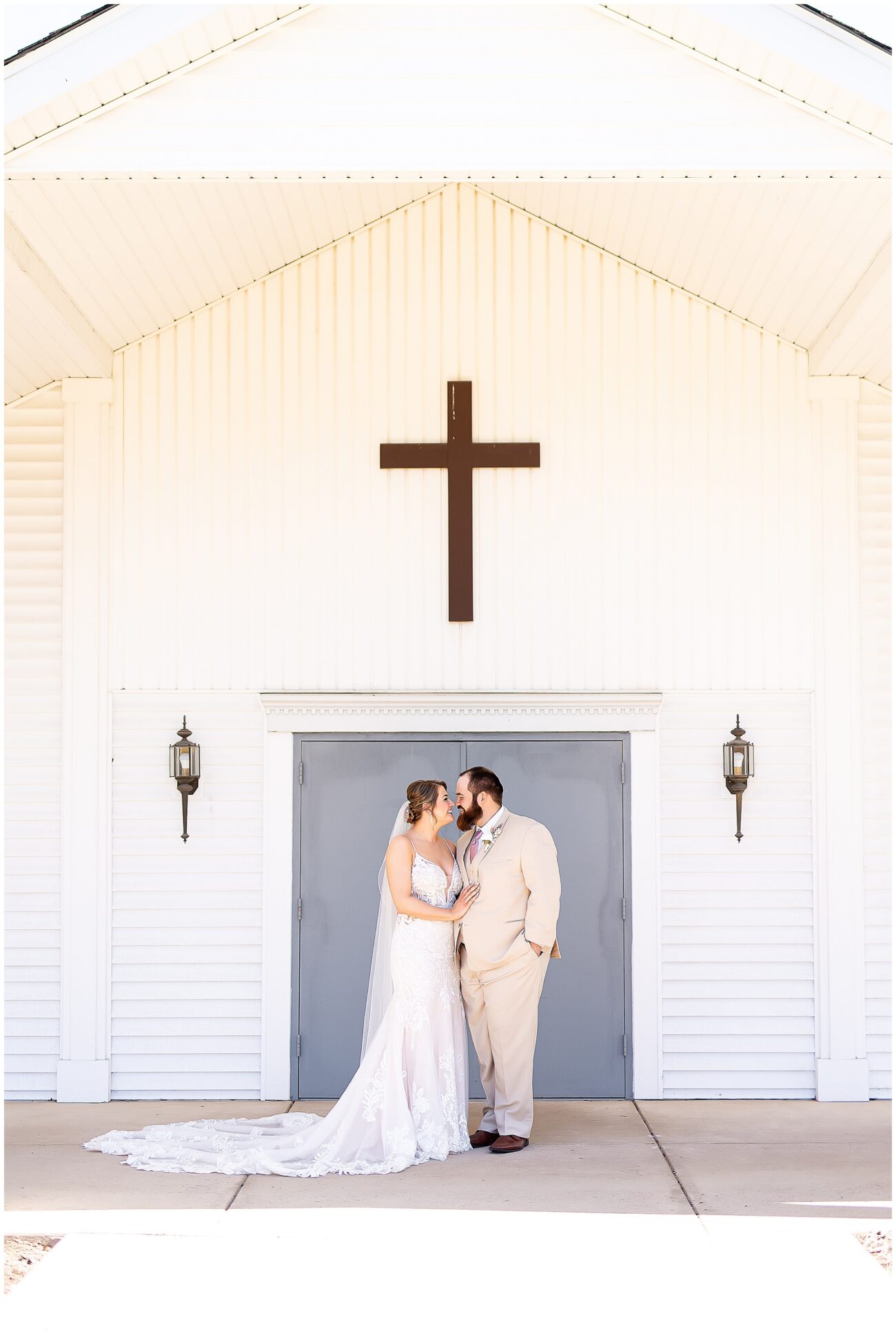 A small town wedding for Casey and Adam. The bride and groom pose for a portrait outside of the church in front of blue doors underneath a cross.

Saint John the Baptist Catholic Church, L'erable, IL. 

Photo taken by Mager Image Photography.