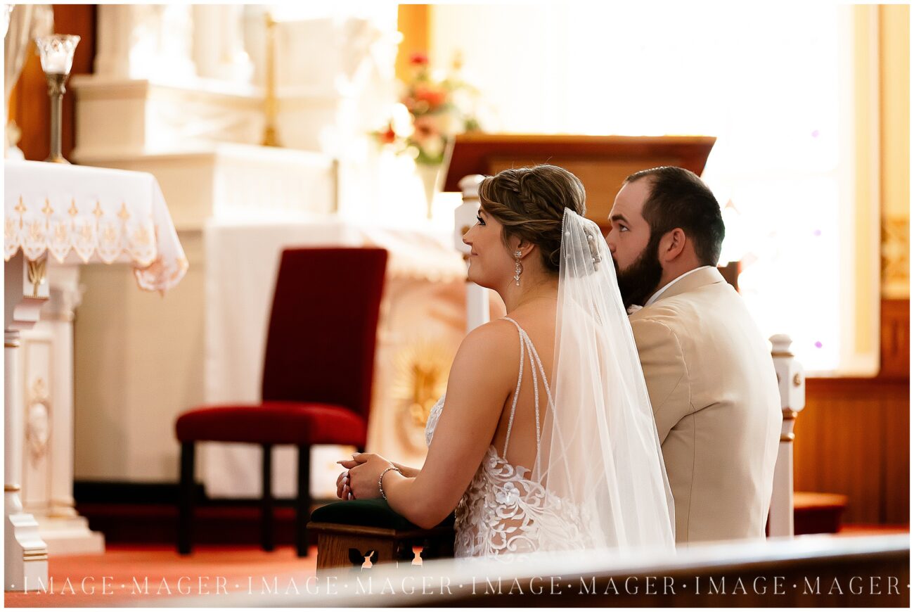 A small town wedding for Casey and Adam. A photo of the bride and groom kneeling at the front of the church during their catholic wedding ceremony. Focused on the bride smiling up at the altar.

Saint John the Baptist Catholic Church, L'erable, IL. 

Photo taken by Mager Image Photography.
