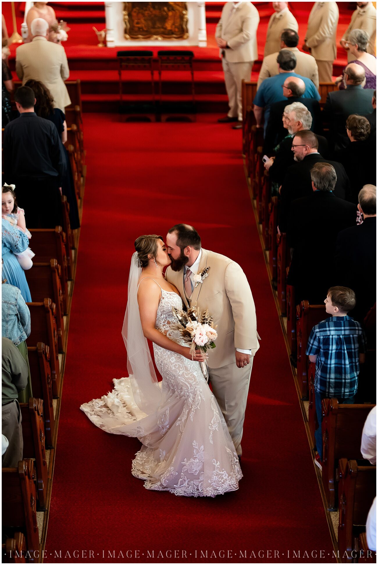 A small town wedding for Casey and Adam. The bride and groom share a kiss while walking back up the aisle after their wedding ceremony.

Saint John the Baptist Catholic Church, L'erable, IL. 

Photo taken by Mager Image Photography.