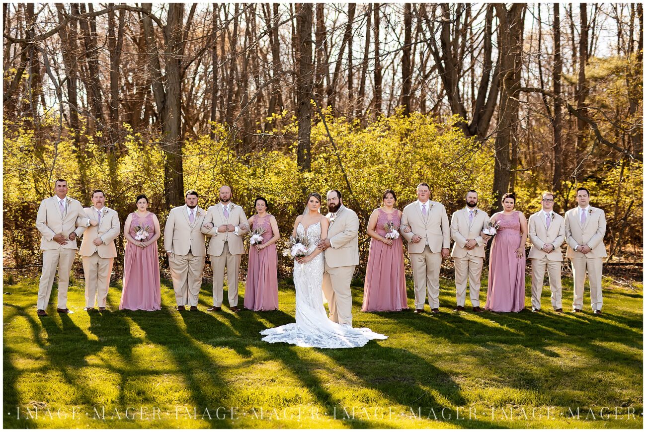A small town wedding for Casey and Adam. A photo of the bride and groom of their wedding party. With 4 bridesmaids in pink gowns and 8 groomsmen all looking at the camera.

L'erable, IL. 

Photo taken by Mager Image Photography.