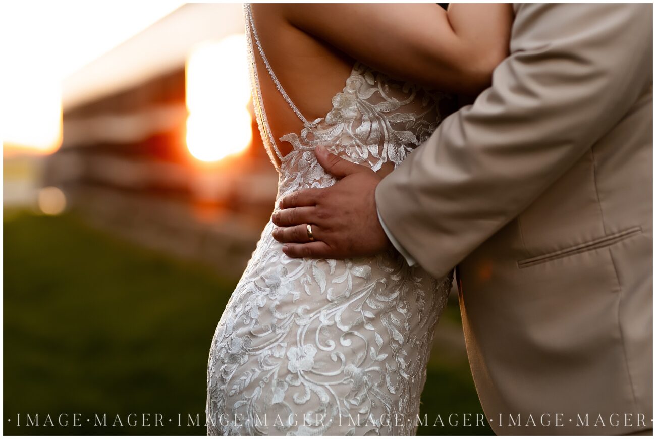 A small town wedding for Casey and Adam. A close up sunset image of the groom's ring hand on his bride's hip.

Kankakee County Fairgrounds, Kankakee, IL.

Photo taken by Mager Image Photography.