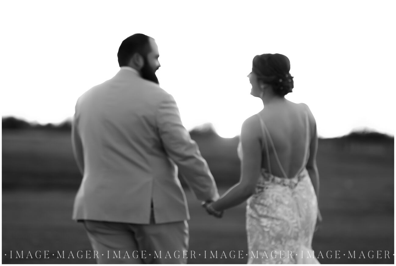 A small town wedding for Casey and Adam. A slightly blurred black and white image o the bride and groom walking away from the camera toward the sunset.

Kankakee County Fairgrounds, Kankakee, IL.

Photo taken by Mager Image Photography.